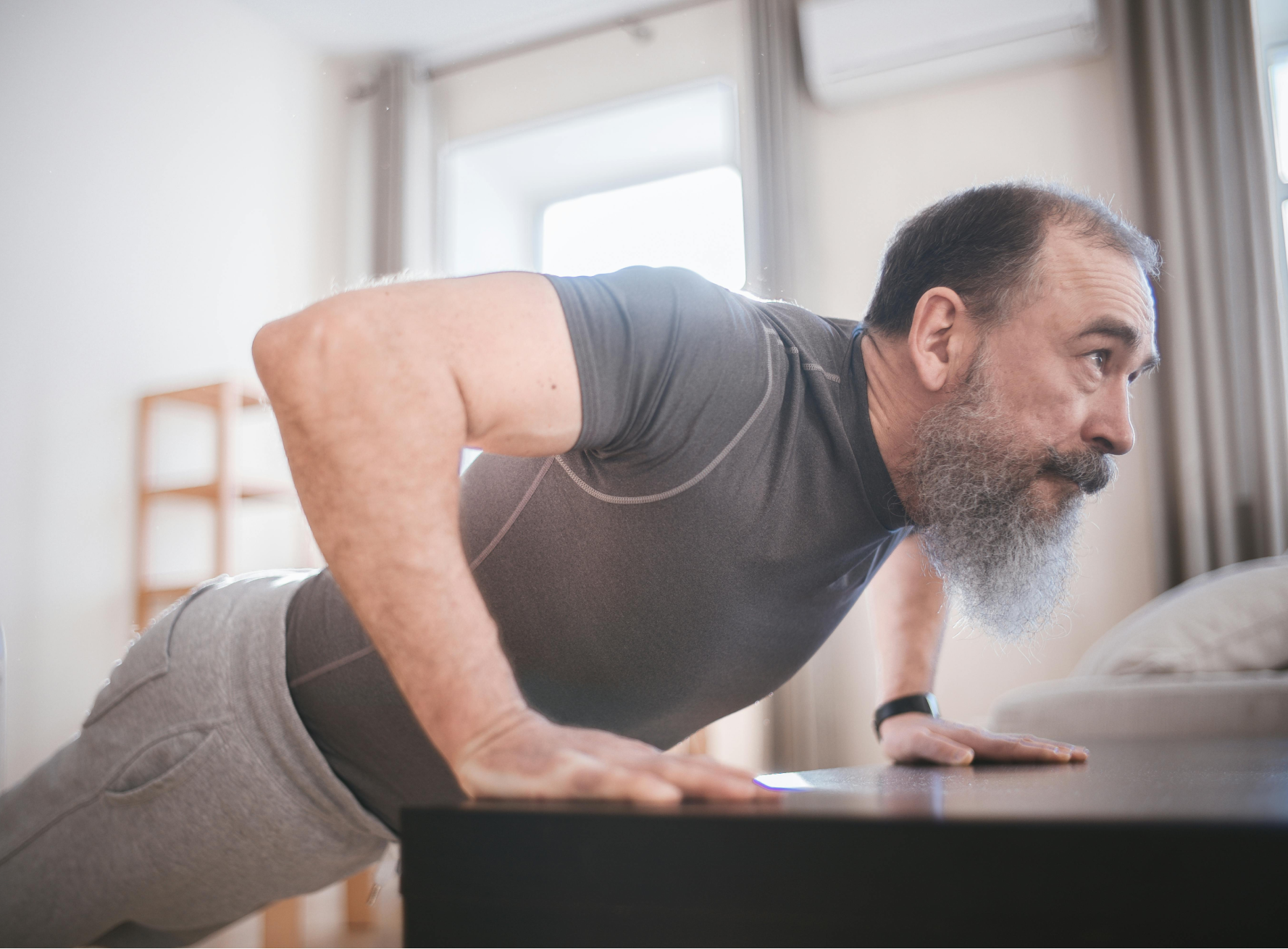 A Man Doing Push Up at Home. Photo by Mikhail Nilov: https://www.pexels.com/photo/a-man-doing-push-up-at-home-6975781/