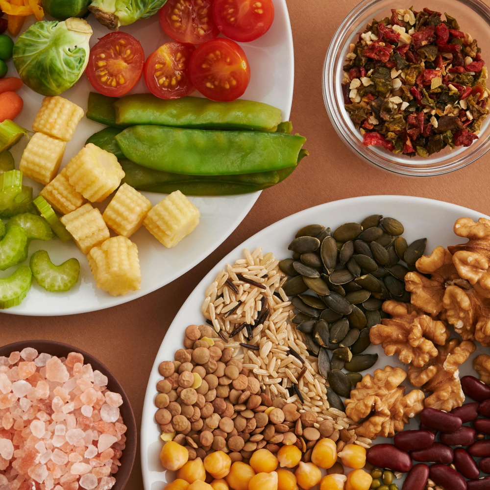 A vibrant flatlay of colorful vegetables and nuts showcasing a balanced diet concept.